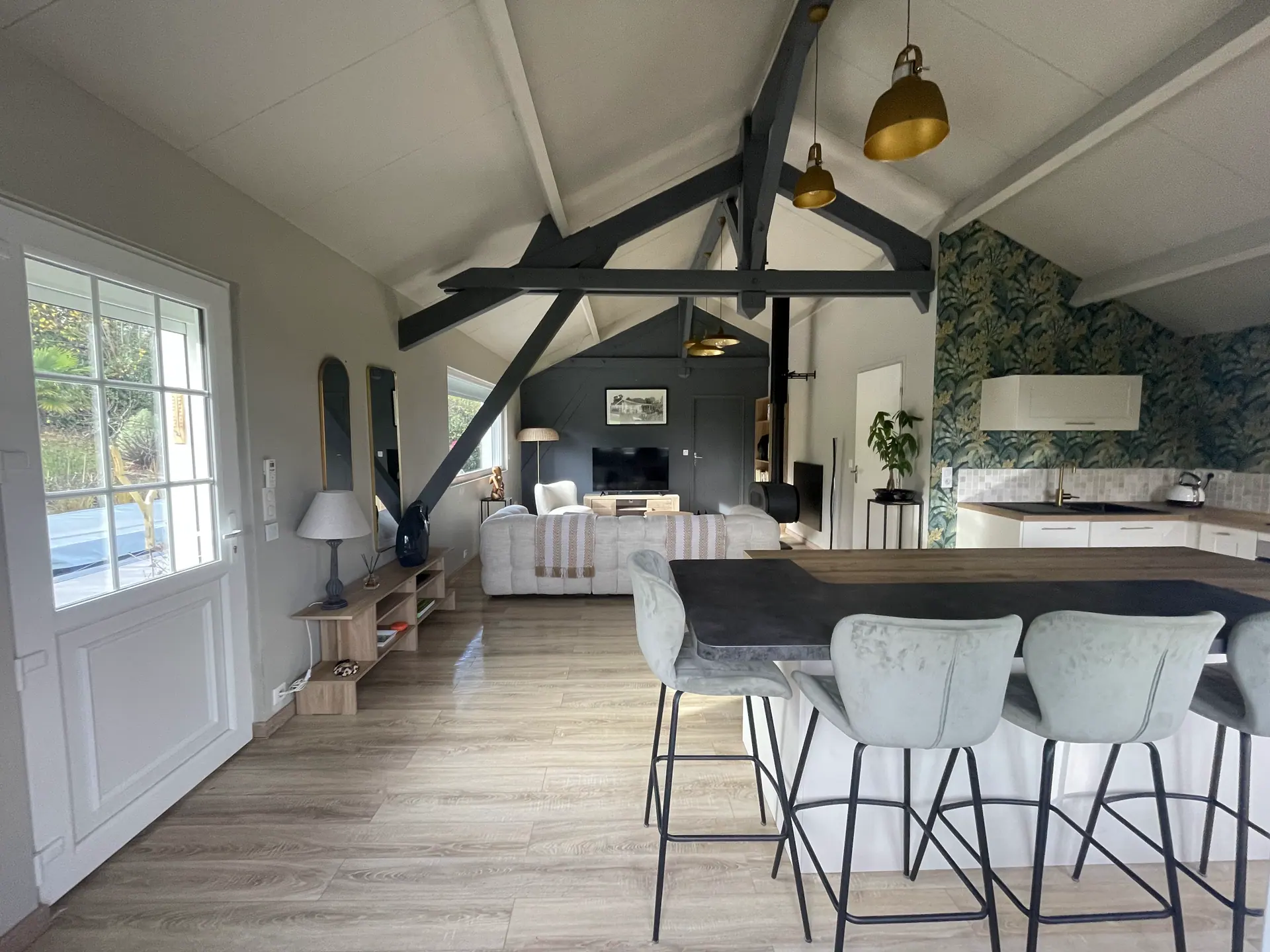 La cuisine ouverte et son bar, sous la charpente grise du Chalet Normand