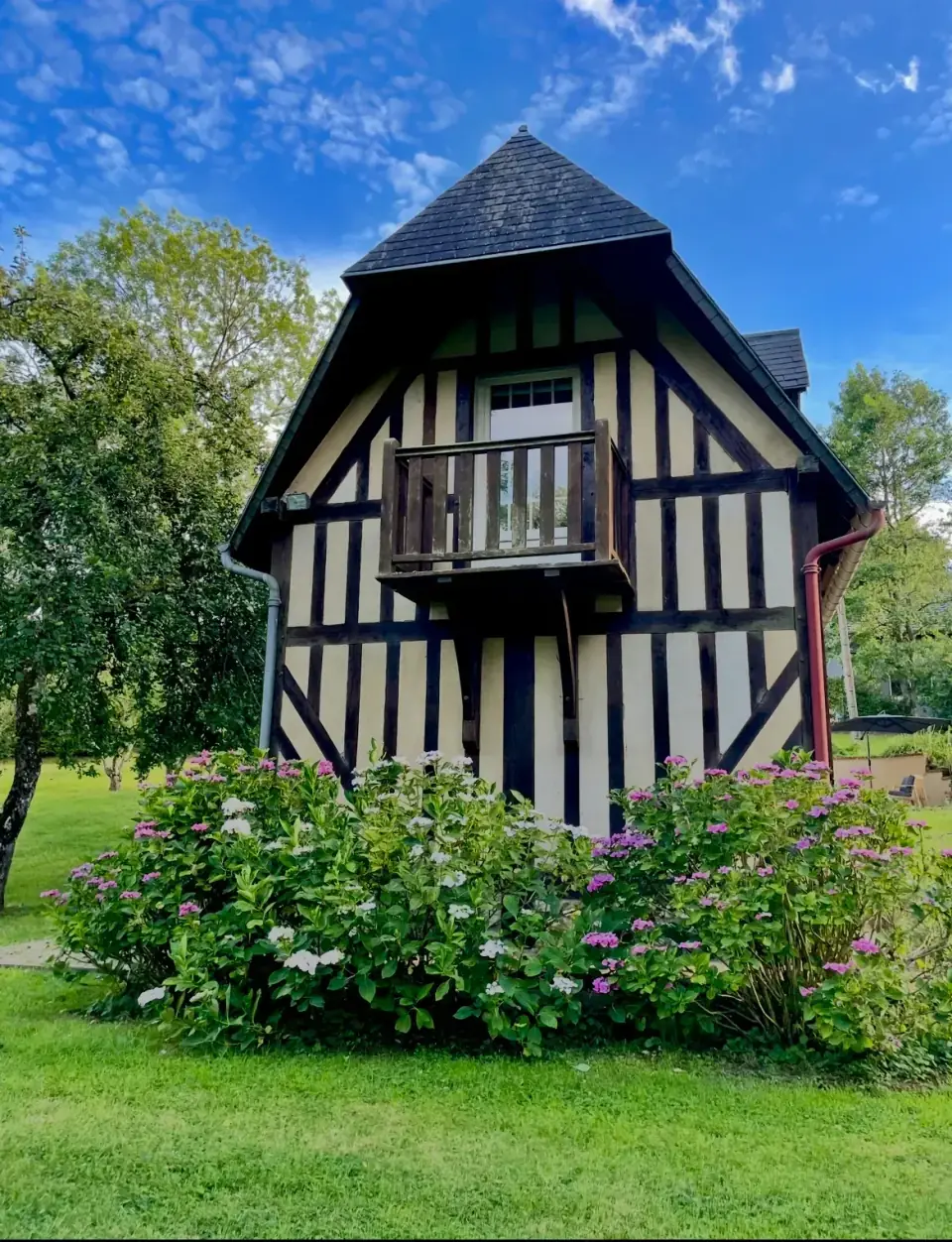 La façade à colombages de Reinette Grise, son balcon et ses hortensias