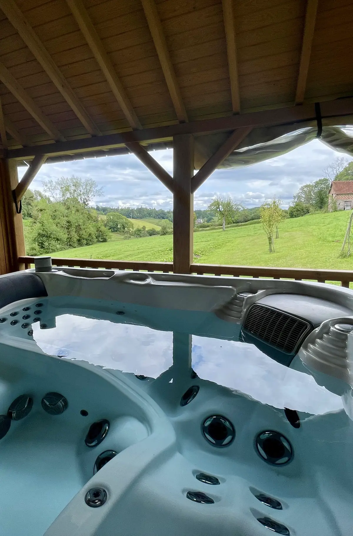 Le jacuzzi extérieur du Hameau sous son kiosque, face aux prés et au vallon
