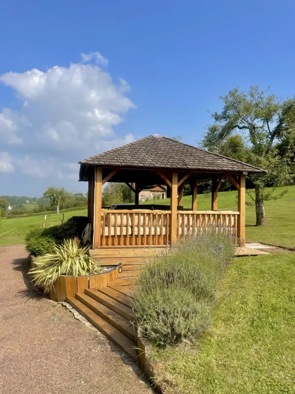 Le kiosque de bois qui abrite le jacuzzi, au bout de son allée