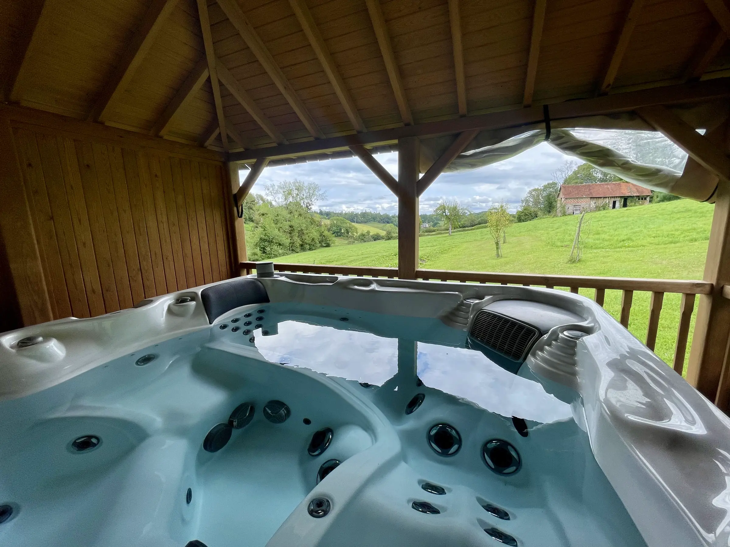 Le jacuzzi du Hameau sous son kiosque de bois, au milieu du pré