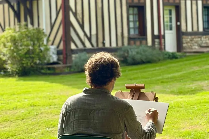 Cyp, dessinateur, à son chevalet sur la pelouse, face à Reinette Grise, au Hameau des Prés-Verts